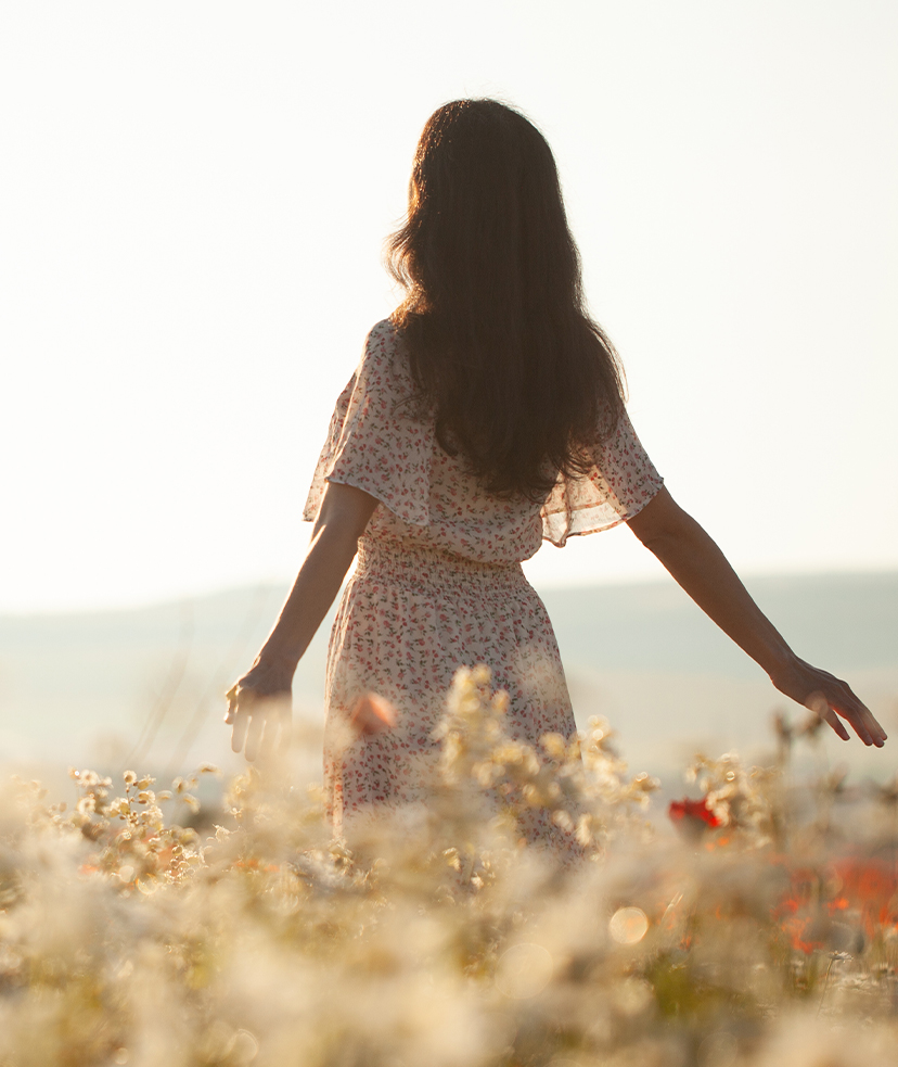 Photo of a woman walking through a field of flowers