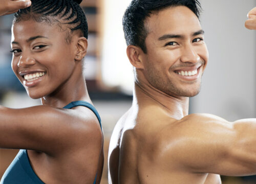 Photo of a woman and man flexing at the gym after truFlex® muscle sculpting treatments